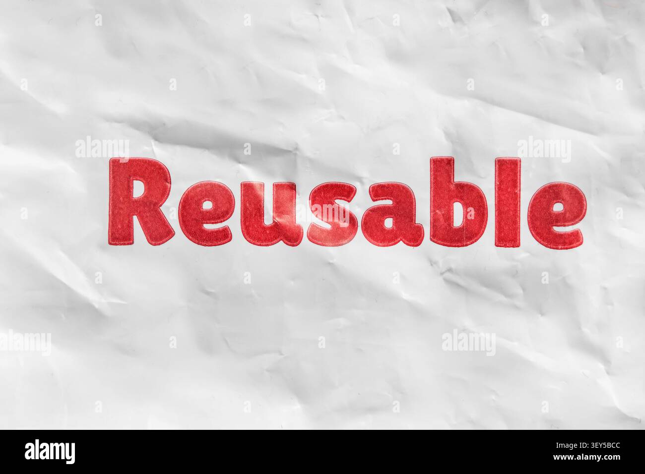 Parola rossa riutilizzabile stampata su sfondo in plastica deformato bianco Foto Stock