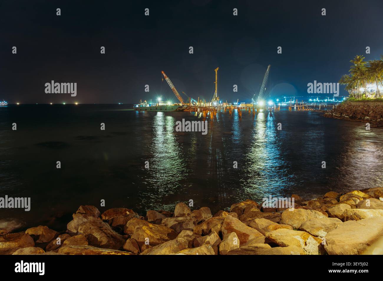Gru e chiatte da costruzione che lavorano in mare di notte a Phu Quoc Foto Stock