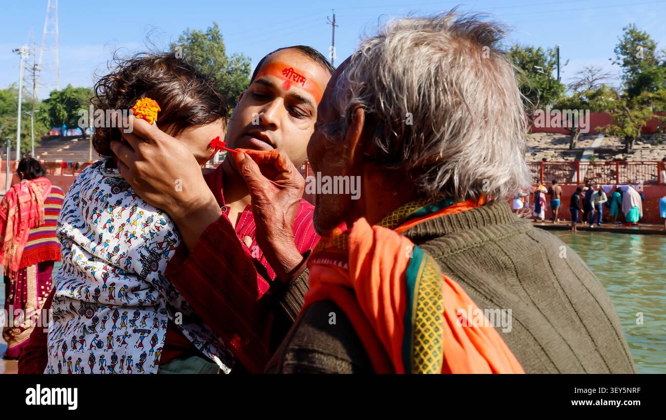 Il rituale devozionale Tilak con bambini e anziani durante il pellegrinaggio religioso ad Ayodhya viene girato al sarayu ghat ayodhya uttar pradesh india il 0 marzo Foto Stock
