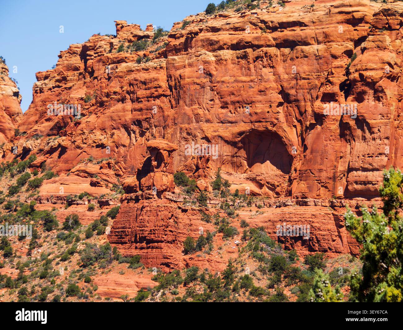 Una grotta formata dagli agenti atmosferici e dall'antica attività geologica è facilmente visibile su questa formazione di redstone che confina con la Foresta Nazionale di Coconino Foto Stock