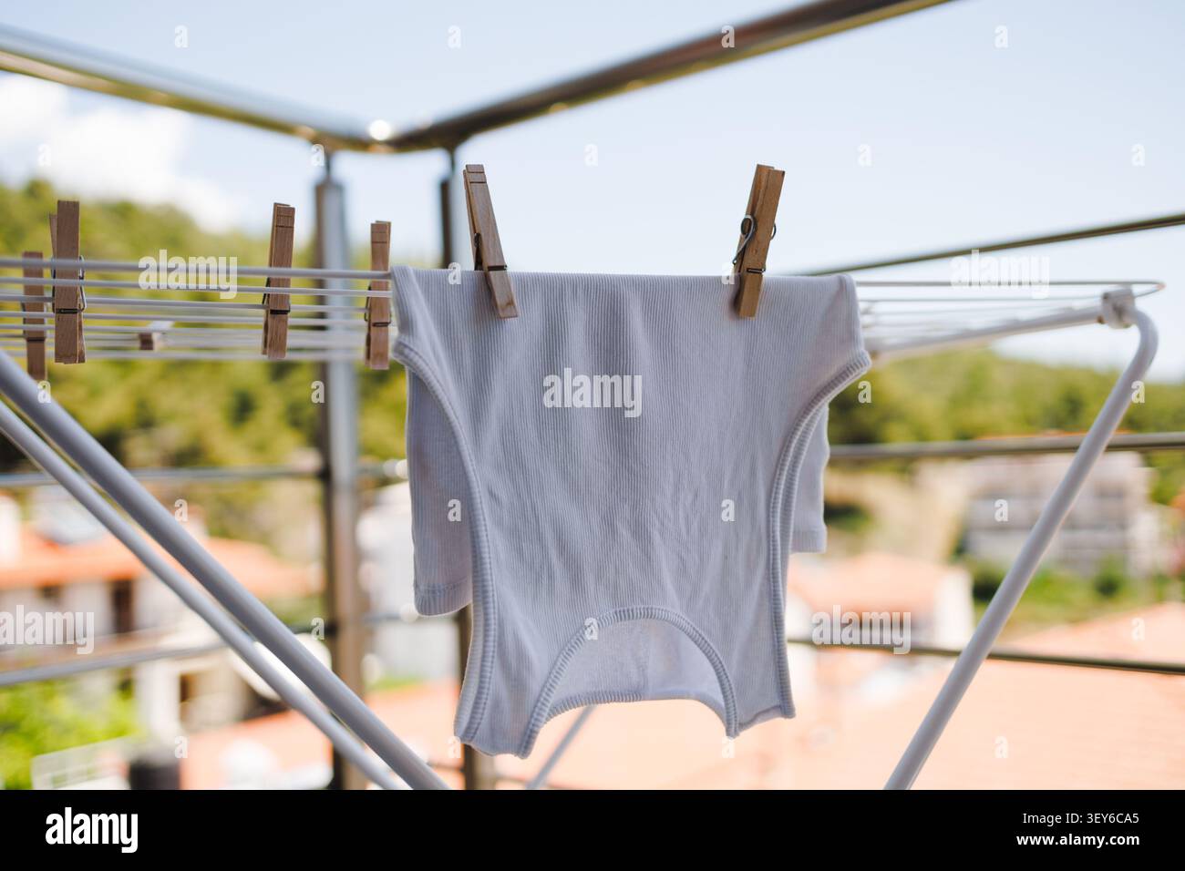 Stendibiancheria con T Shirt bianca su balcone Foto Stock