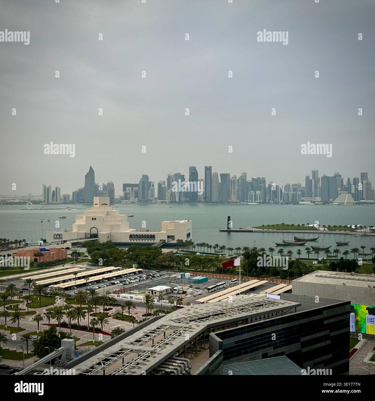 Vista elevata del Museo d'Arte Islamica e del suo parco sul lungomare, con la baia di Doha e lo skyline di West Bay sullo sfondo, Qatar. - Immagine stock catturata con smartphone