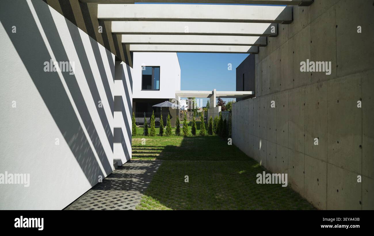 Moderna architettura in cemento e minimalista con forti ombre geometriche sul cortile di una villa residenziale Foto Stock