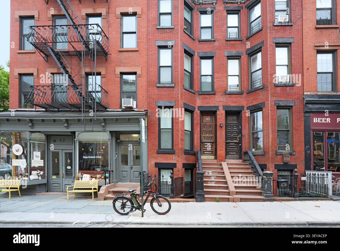 New York City, vecchio edificio di appartamenti con negozi al piano terra Foto Stock