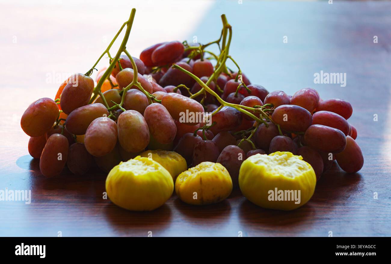 Uva e fichi, uva rosa e fichi gialli in tavola Foto Stock