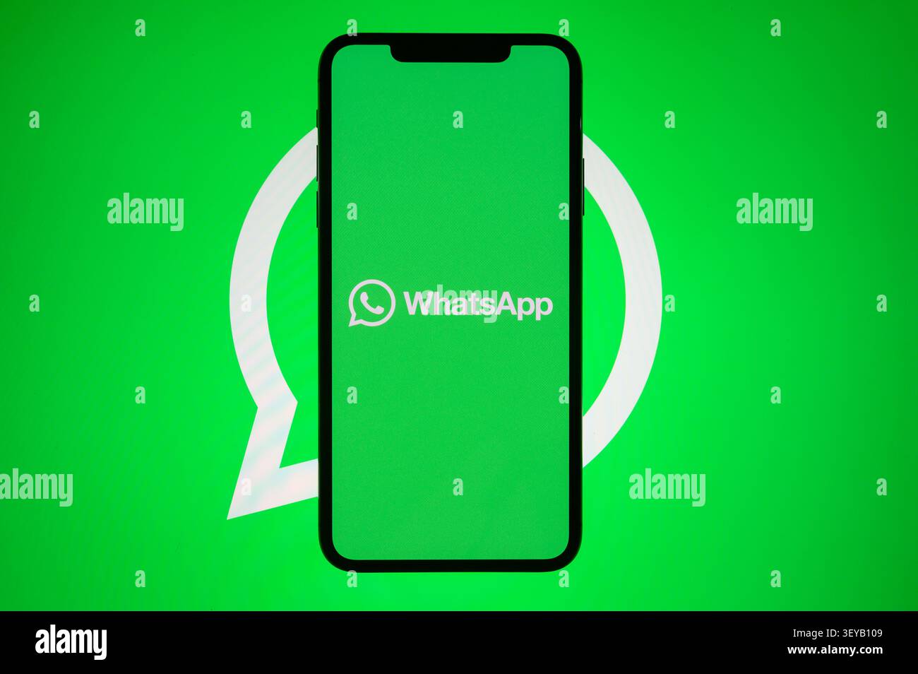 Parigi, Francia - 2 luglio 2026: Smartphone verticale con logo WhatsApp posizionato sopra lo sfondo di un'icona verde. Foto Stock