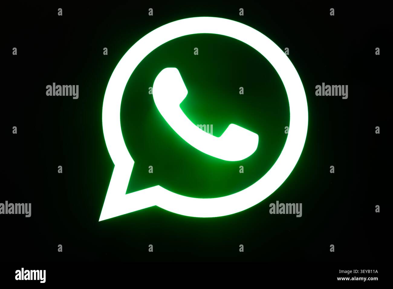 Parigi, Francia - 2 luglio 2026: Icona luminosa del logo WhatsApp visualizzata su uno schermo di sfondo nero. Foto Stock