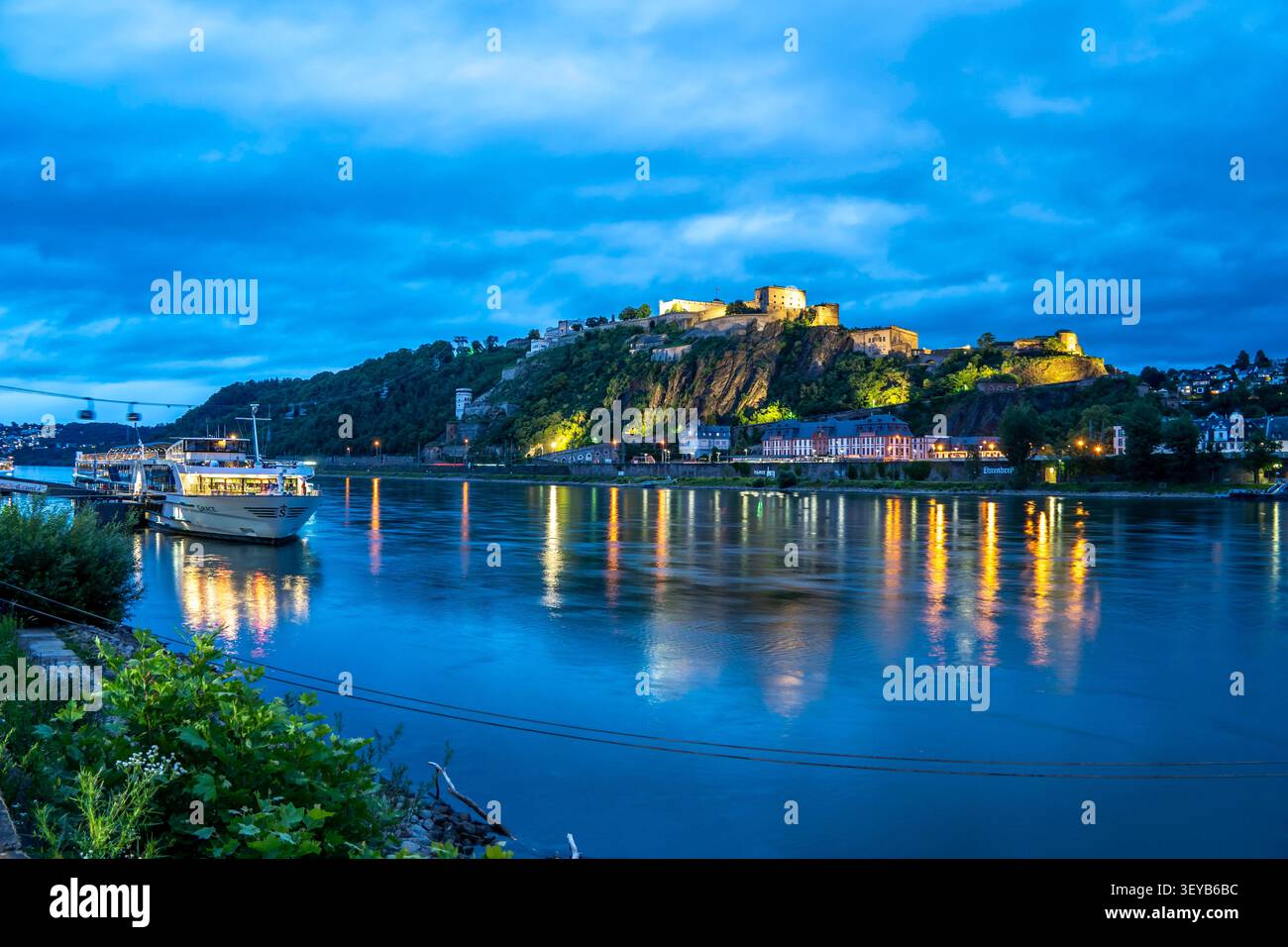 Fortezza di Ehrenbreitstein, sulla riva destra del Reno, di fronte al Deutsches Eck, illuminata di notte, una barca turistica sulla riva sinistra, Koble Foto Stock