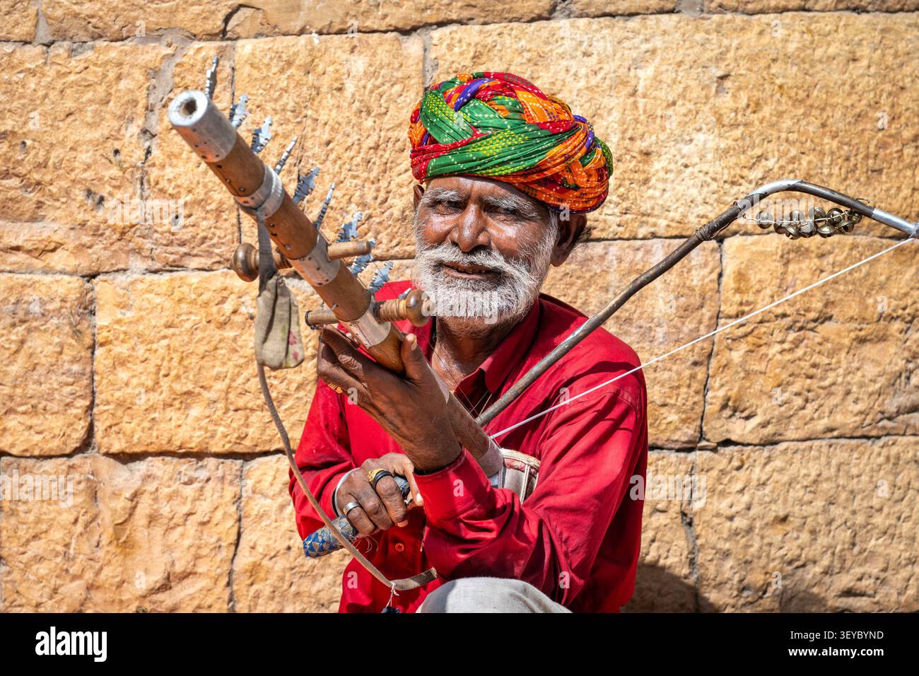 Musicista di strada che suona una Ravanhatta, un tradizionale strumento musicale folk del Rajasthan a Jaisalmer, Rajasthan, India Foto Stock