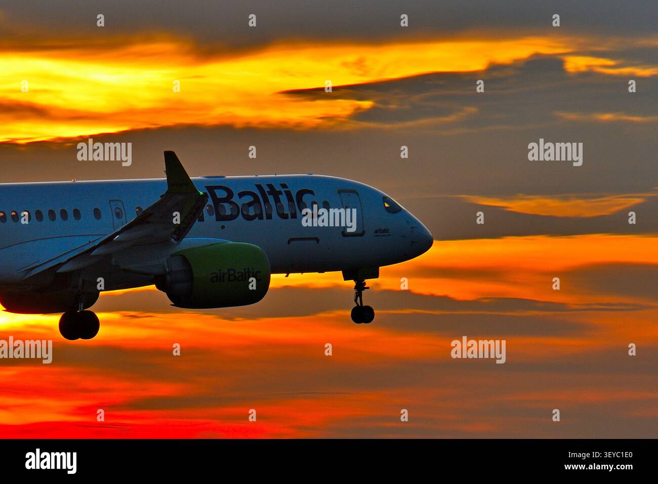 Belgrado, Serbia, 2 nov. 2025. Primo piano del profilo di un aereo passeggeri Air Baltic Airbus A220 che atterra contro un drammatico cielo del tramonto invernale Foto Stock