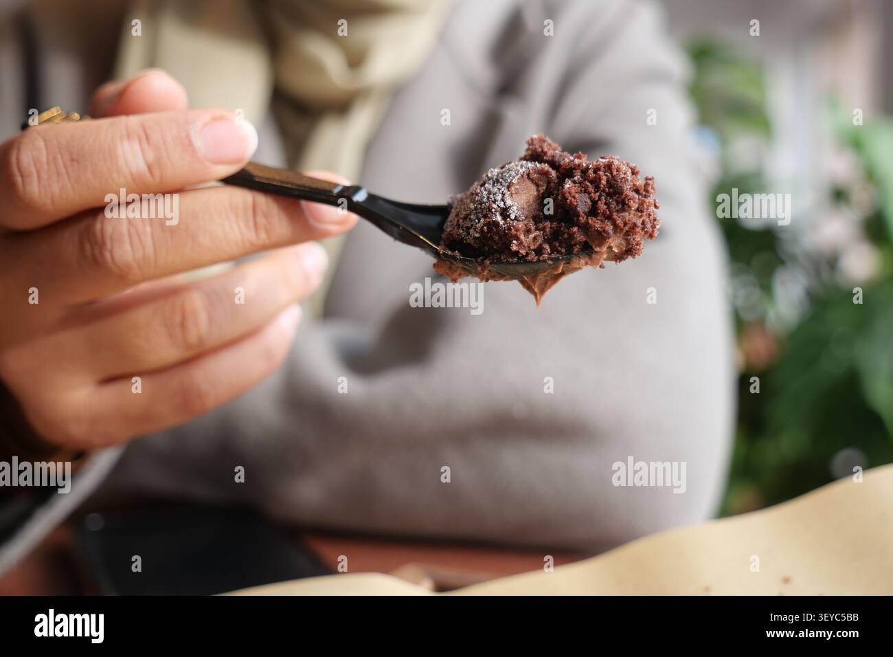 Gustate il dessert con un cucchiaio in un ambiente accogliente Foto Stock