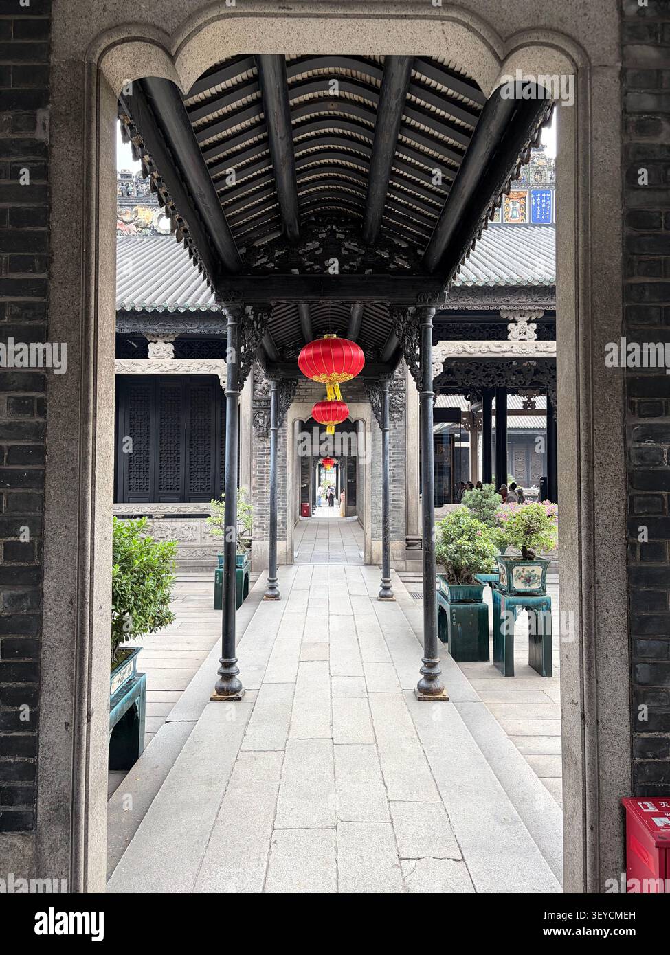 30 ottobre 2025, Guangzhou, Cina - Vista aerea dall'alto verso il basso del cortile dell'Accademia Chen Clan con architettura in legno nero ornato e lanterna rossa, Guangzhou - Immagine stock catturata con smartphone