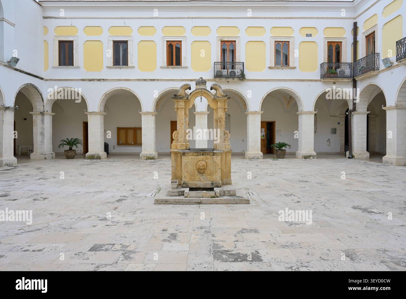 Cortile in pietra di Palazzo S. Domenico in comune di Manfredonia con pozzo d'acqua storico del XVIII secolo Foto Stock