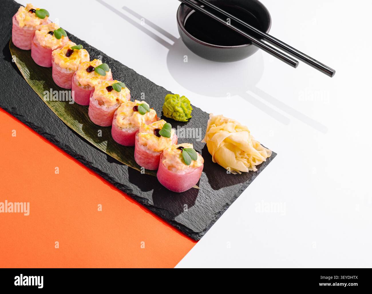 Panini di sushi al forno con tonno piccante, microgreen, zenzero, wasabi e salsa di soia su una tavola di ardesia Foto Stock