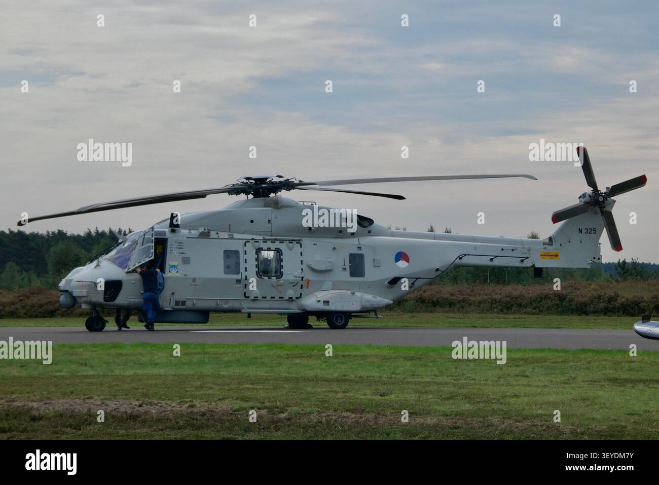 Elicottero NH90 NFH della Royal Netherlands Air Force (immatricolazione N 325) parcheggiato sull'asfalto con equipaggio visibile dalla porta della cabina di pilotaggio. Foto Stock