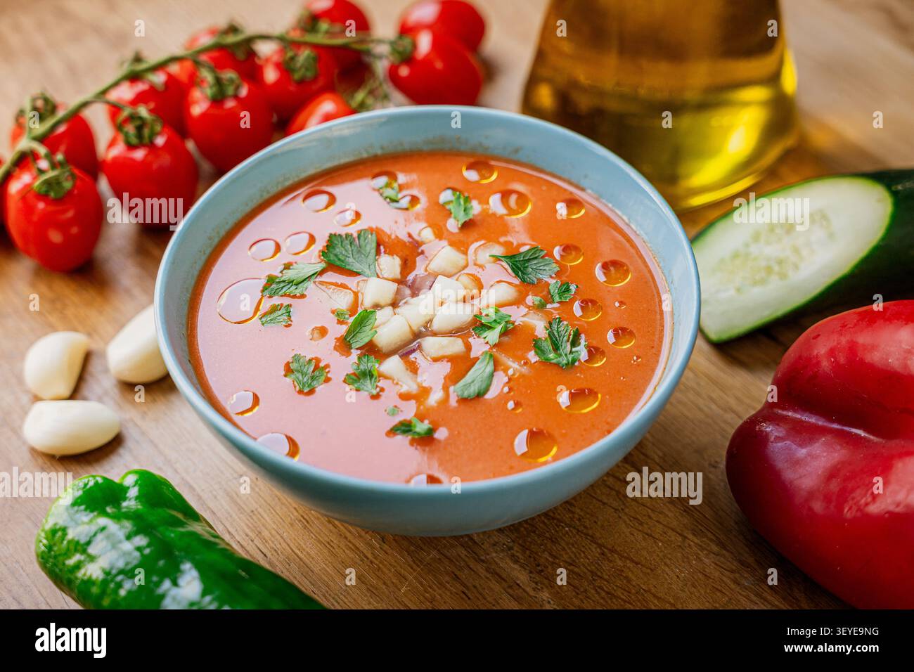 gazpacho spagnolo tradizionale su tavola di legno in ciotola, con ingredienti freschi e olio d'oliva, cibo estivo e zuppa fresca con peperone e pomodoro Foto Stock