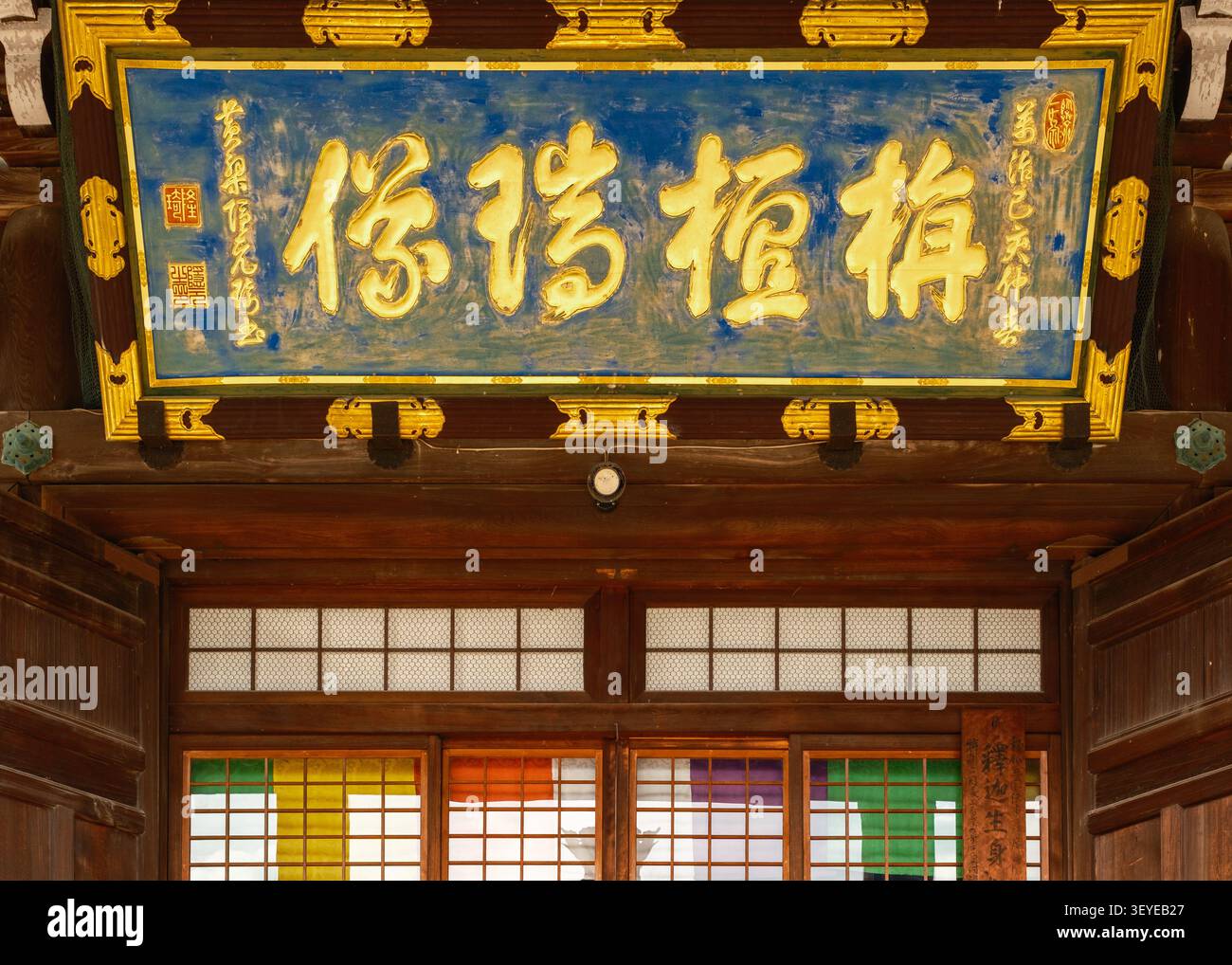 Trave dorata ornata di tempio con caratteri kanji dipinti e pannelli di cornice tradizionali blu, Kyoto, Giappone Foto Stock