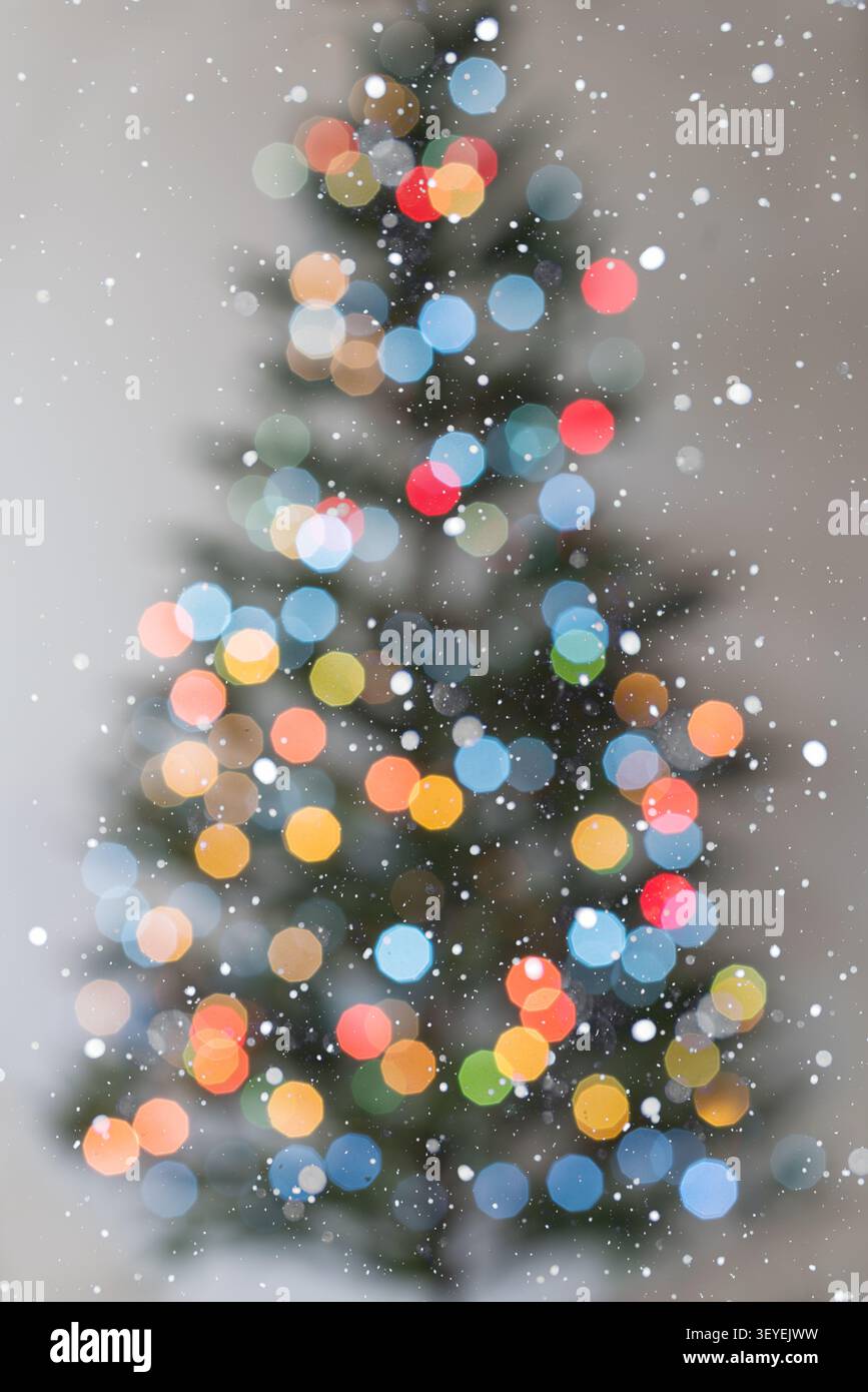 Sfondo verticale per feste con luci bokeh più piccole e fresche e una silhouette più definita sull'albero di Natale su uno sfondo bianco pulito. Caduta sno Foto Stock