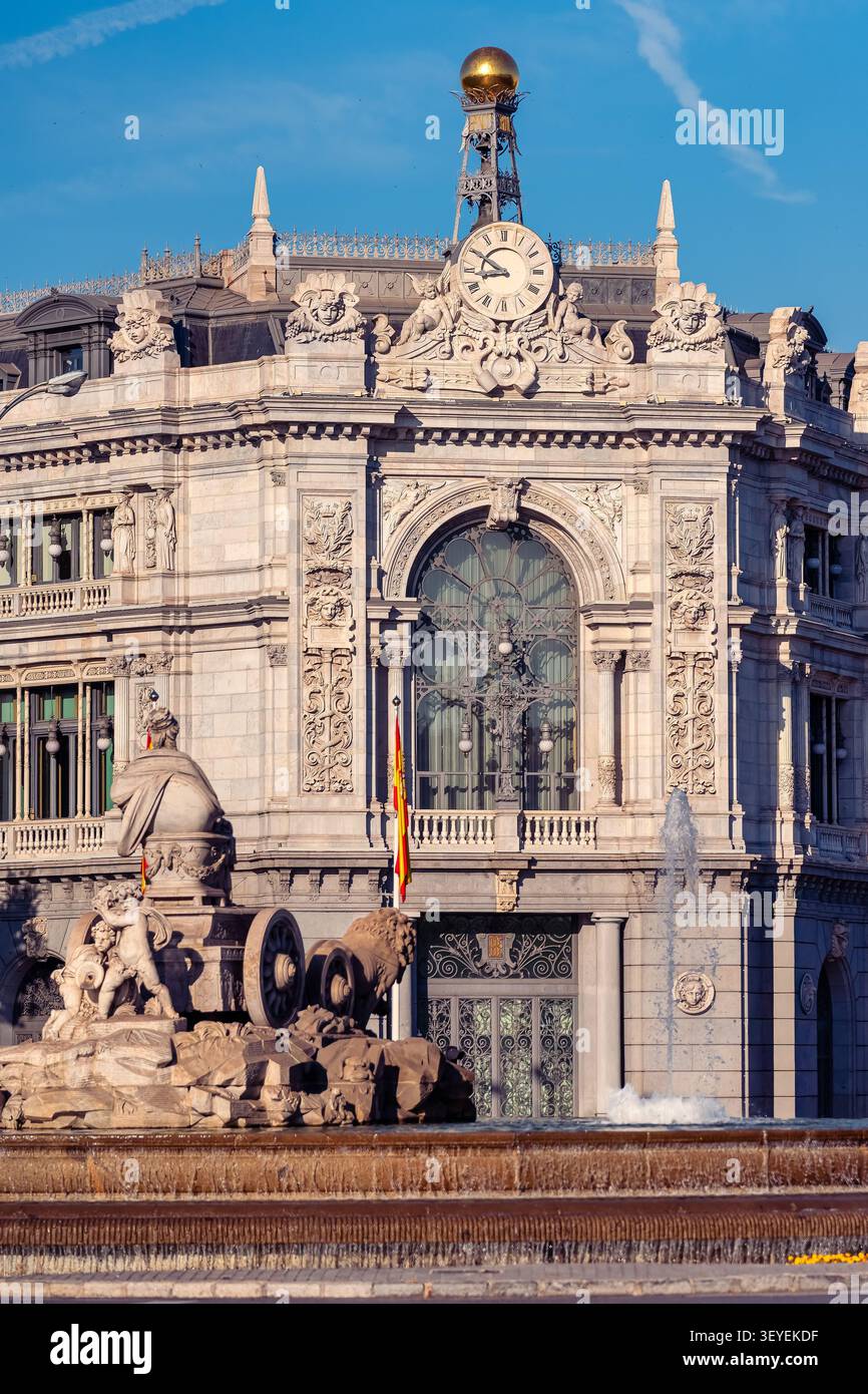 Facciata storica della Banco de Espana con fontana e orologio monumentale a Madrid in Spagna sotto un cielo blu Foto Stock