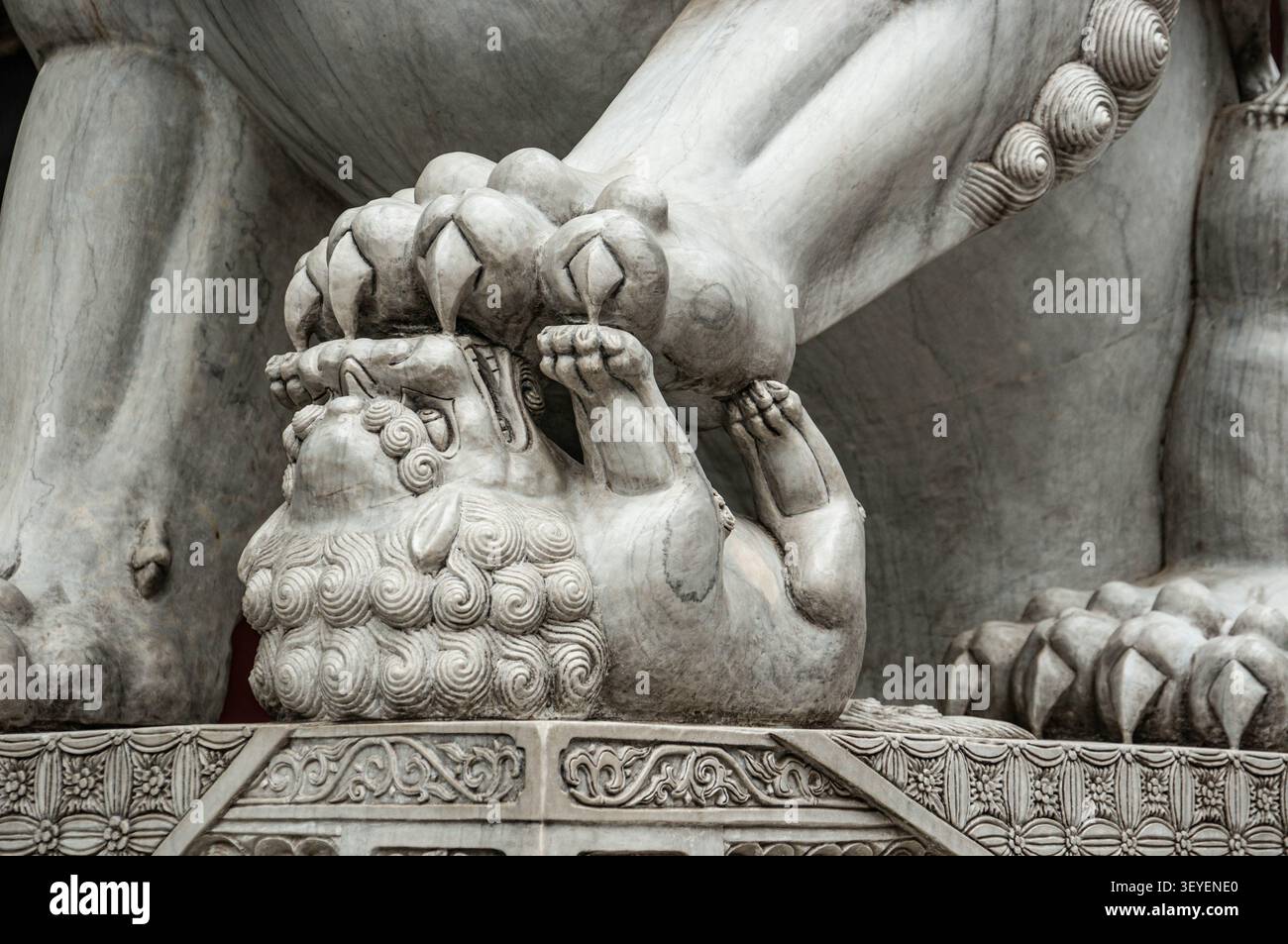Un cucciolo di leone sotto la zampa di una leonessa è un elemento della scultura guardiana di pietra Shi-tsza, Cina. Foto Stock