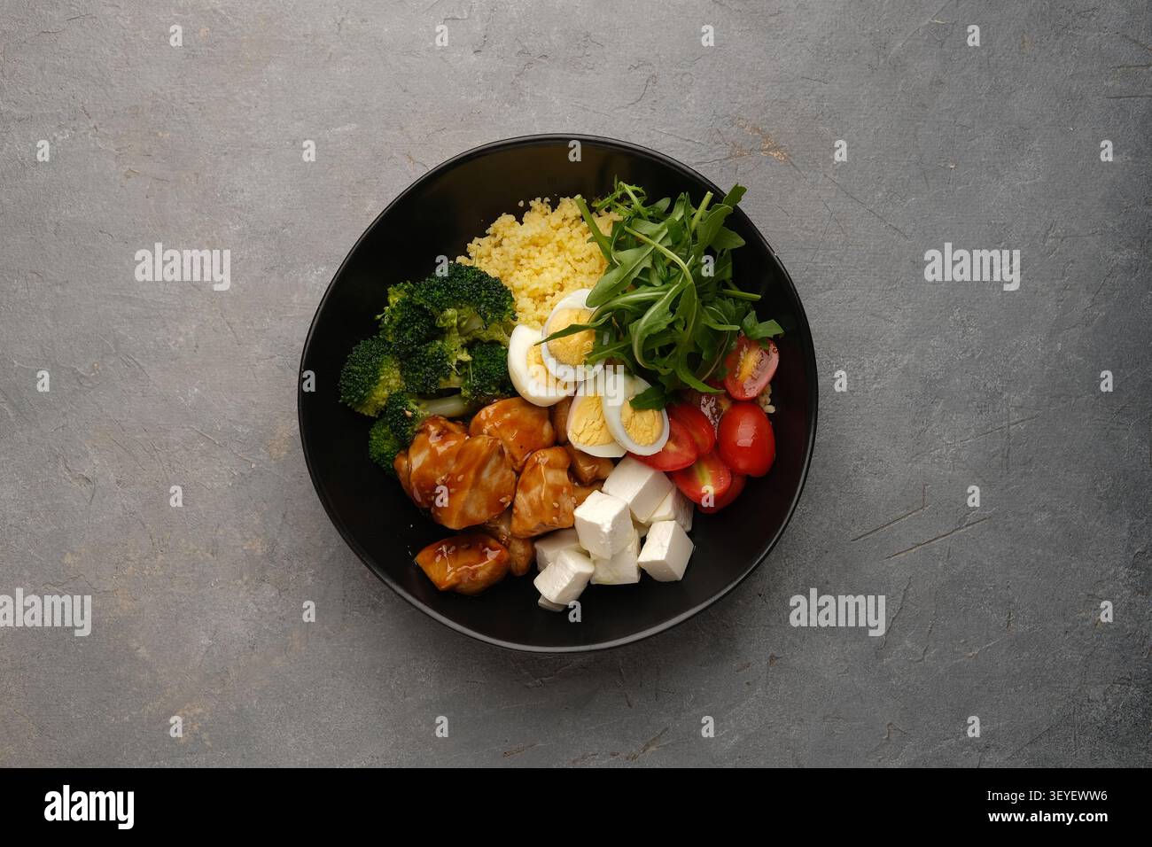 Sana ciotola con pollo glassato, broccoli, uova, pomodori, verdure e feta Foto Stock