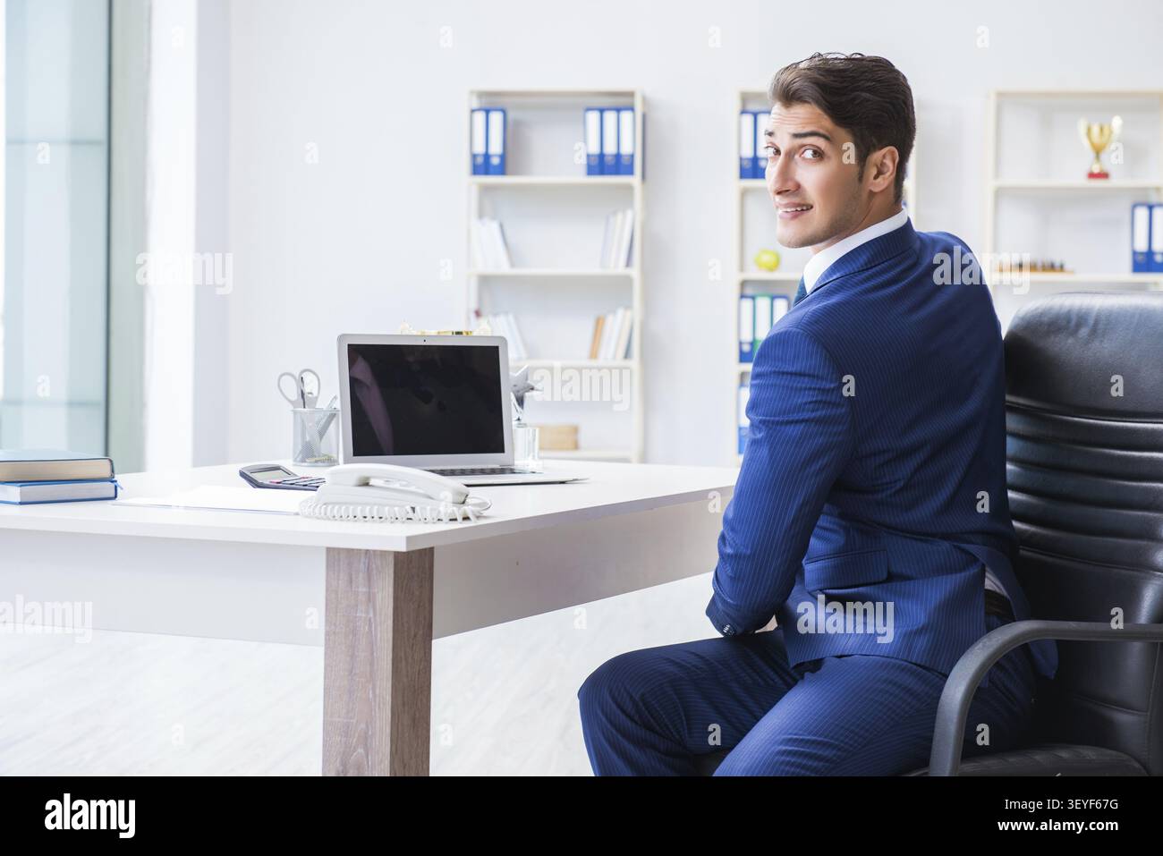 Giovane imprenditore facendo sport stretching al lavoro Foto Stock