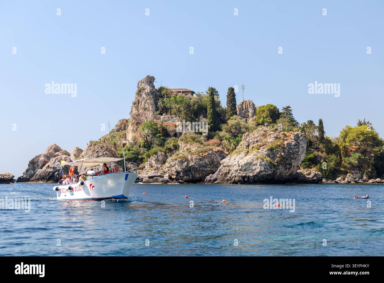 Battello turistico che passa per la riserva naturale di Isola Bella vicino a Taormina, Sicilia, Italia. Foto Stock