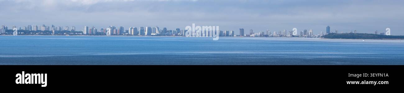 Una spettacolare vista panoramica dalle scogliere di Punta Ballena verso Punta del Este, Uruguay. La vasta spiaggia sabbiosa e l'oceano blu si estendono Foto Stock