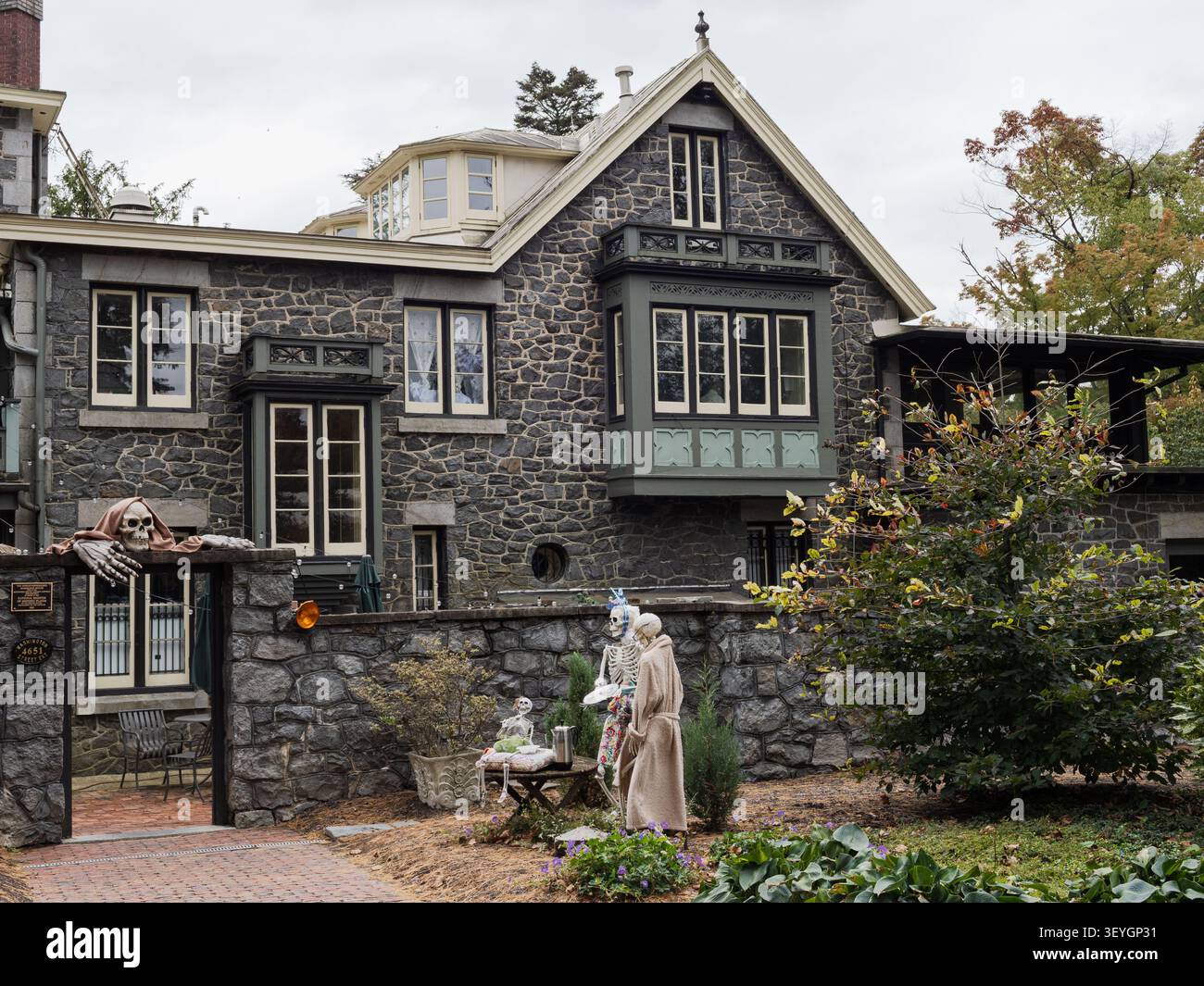 Spaventosi scheletri e oggetti di scena di Halloween adornano l'esterno di un edificio in pietra gotico-vittoriano a Rockwood Park nel Delaware. Foto Stock