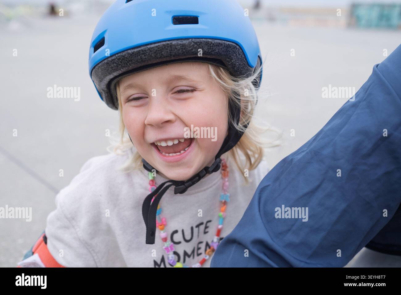 Un bambino con casco sorride all'aperto Foto Stock
