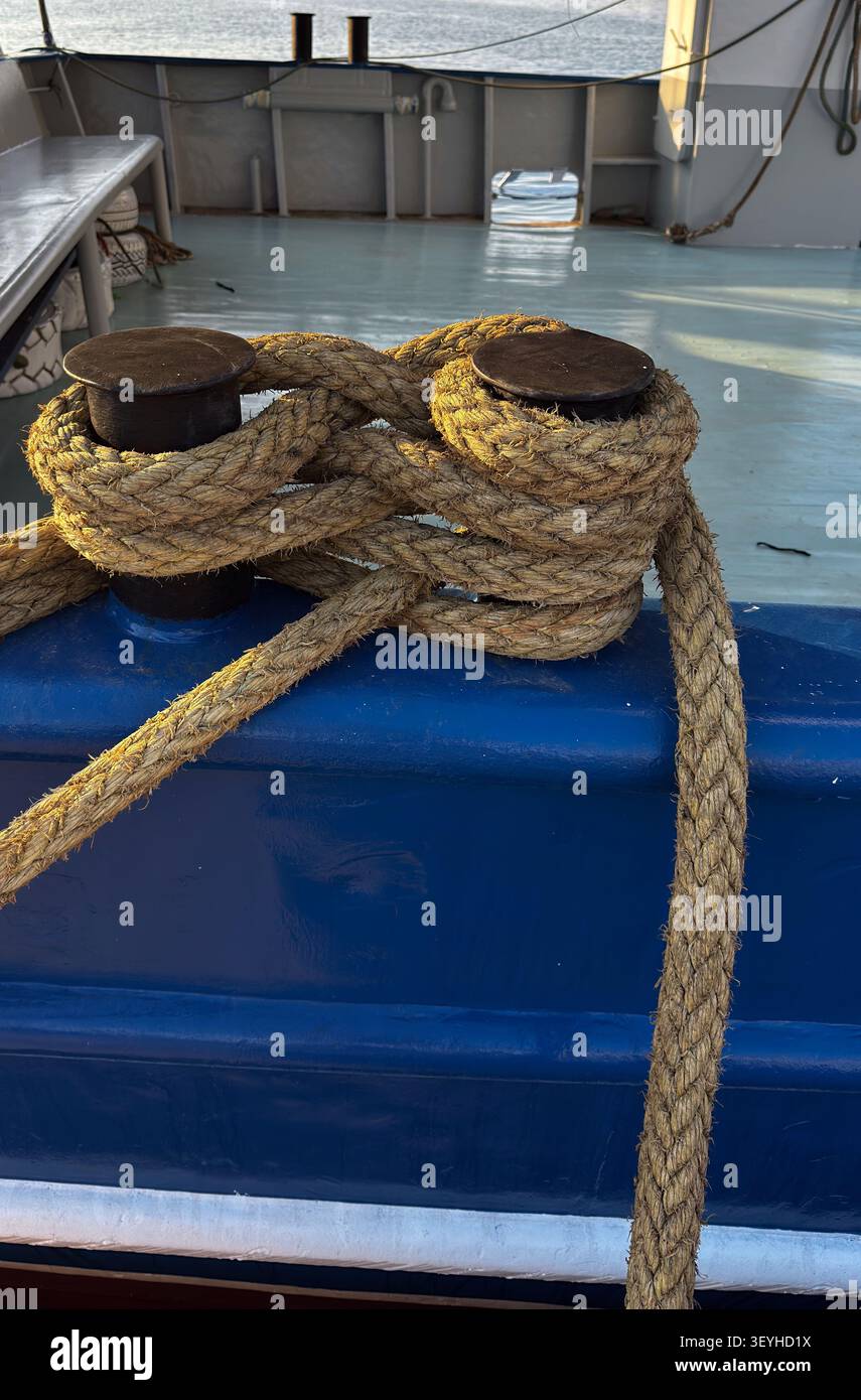 Cavo di ormeggio della nave fissato attorno alle bitte sul ponte di una nave in Grecia Foto Stock