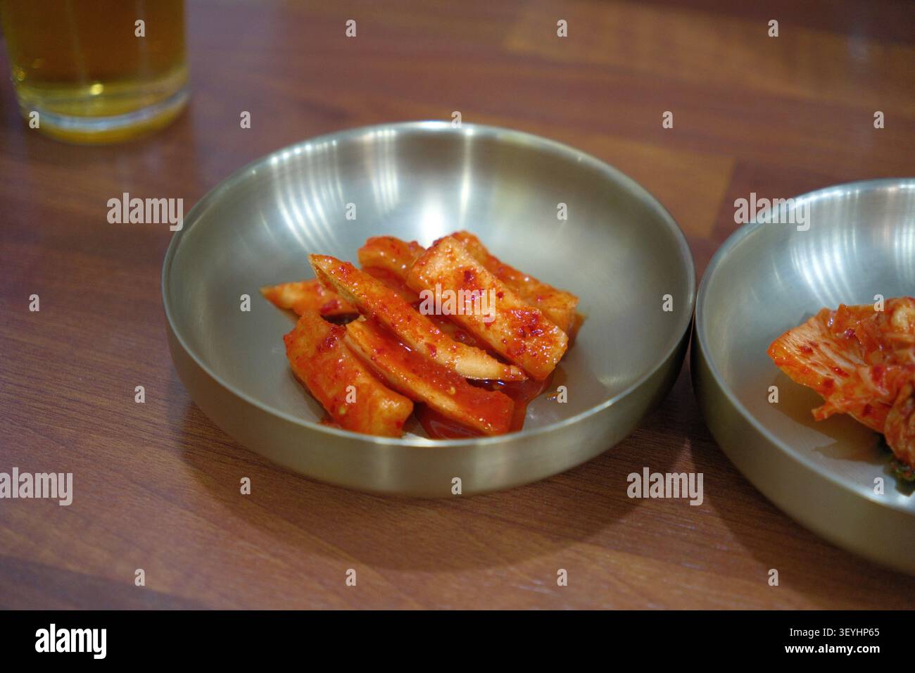 Kimchi e contorni coreani (banchan) serviti in ciotole di acciaio inossidabile Foto Stock
