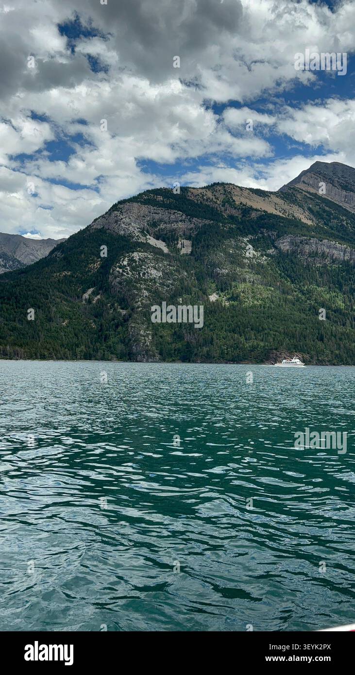 Le aspre cime delle Montagne Rocciose canadesi si innalzano sopra le acque cristalline del lago Waterton, del Waterton Lakes National Park, Alberta, Canada. - Immagine stock catturata con smartphone