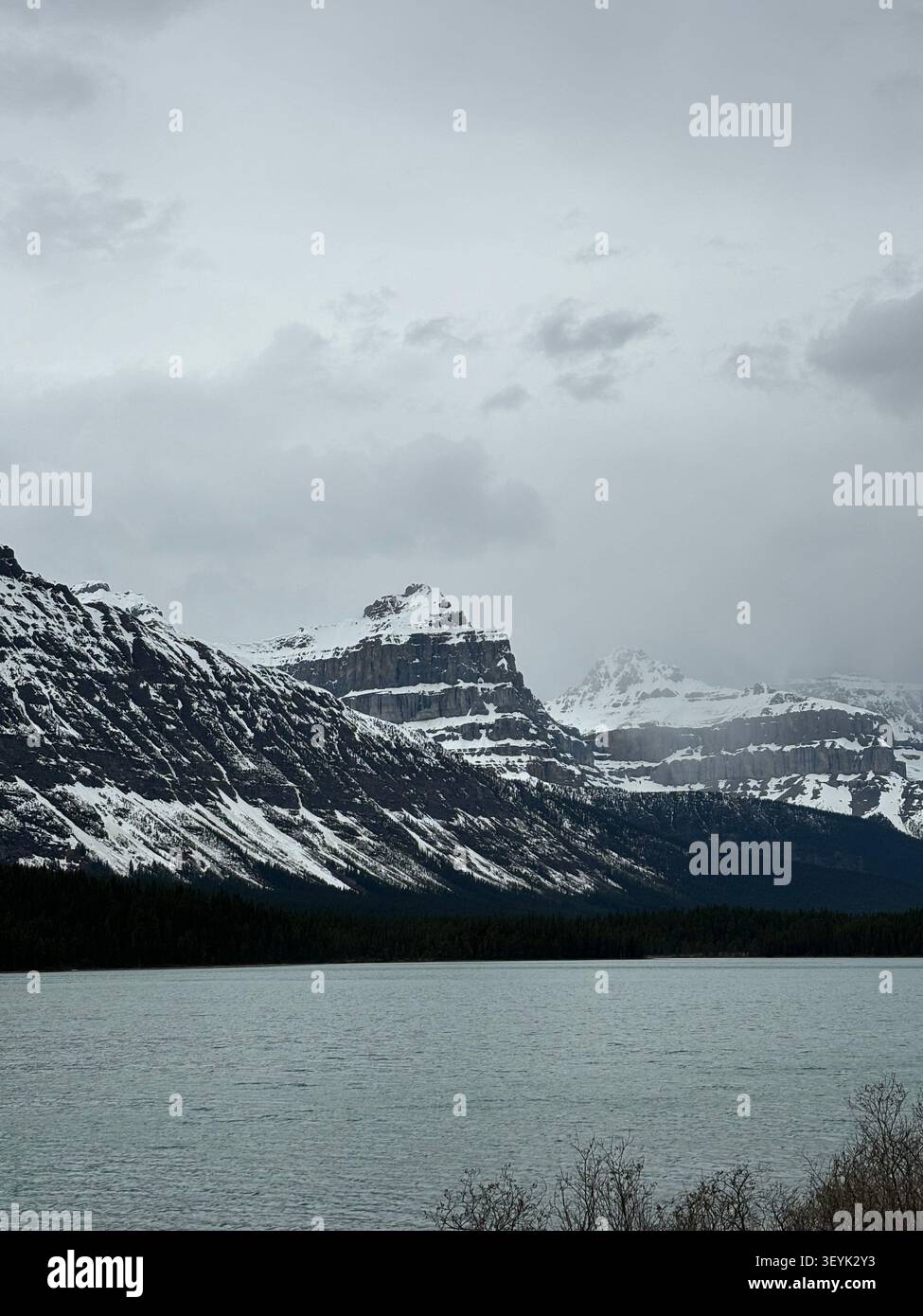 Le acque turchesi del Bow Lake riflettono le vette circostanti, compreso il Crowfoot Mountain, lungo la Icefields Parkway nel Parco Nazionale di Banff, Alberta. - Immagine stock catturata con smartphone