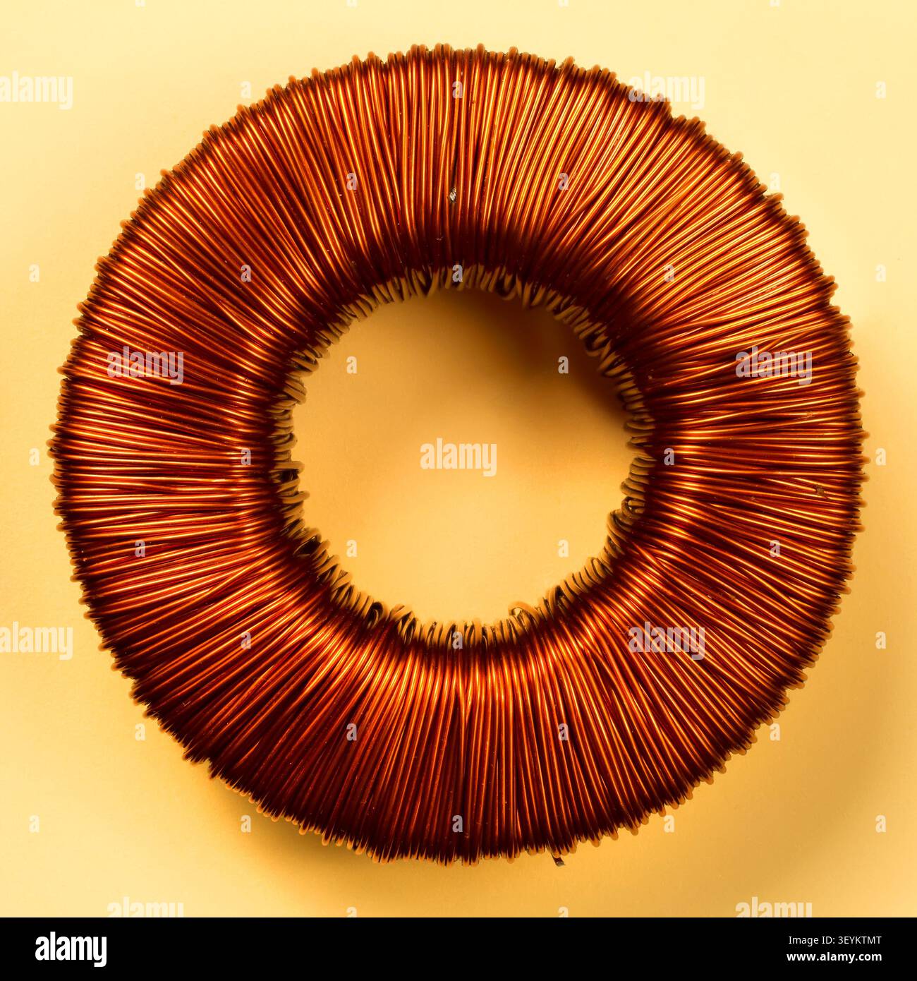 Filo elettrico di colore intenso. Avvolgimento del trasformatore toroidale. Primo piano del filo di rame. Foto Stock