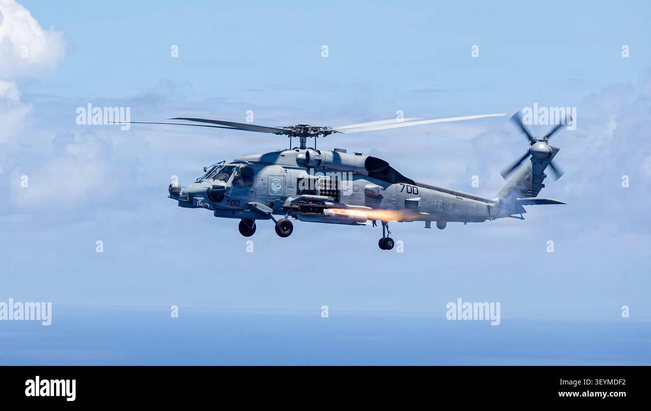 Un MH-60R Seahawk collegato all'Helicopter Maritime Strike Squadron (HSM) 77, spara un razzo da un MH-60R Seahawk durante un'esercitazione di fuoco dal vivo mentre un Foto Stock