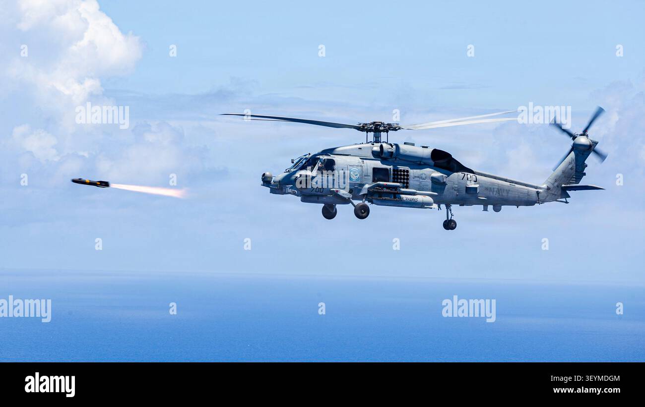 Un MH-60R Seahawk collegato all'Helicopter Maritime Strike Squadron (HSM) 77, spara un razzo da un MH-60R Seahawk durante un'esercitazione di fuoco dal vivo mentre un Foto Stock