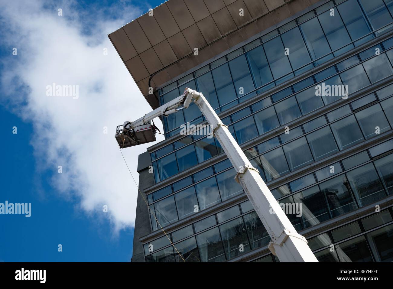 La facciata dell'edificio urbano viene pulita da una macchina per la raccolta di ciliegi Foto Stock