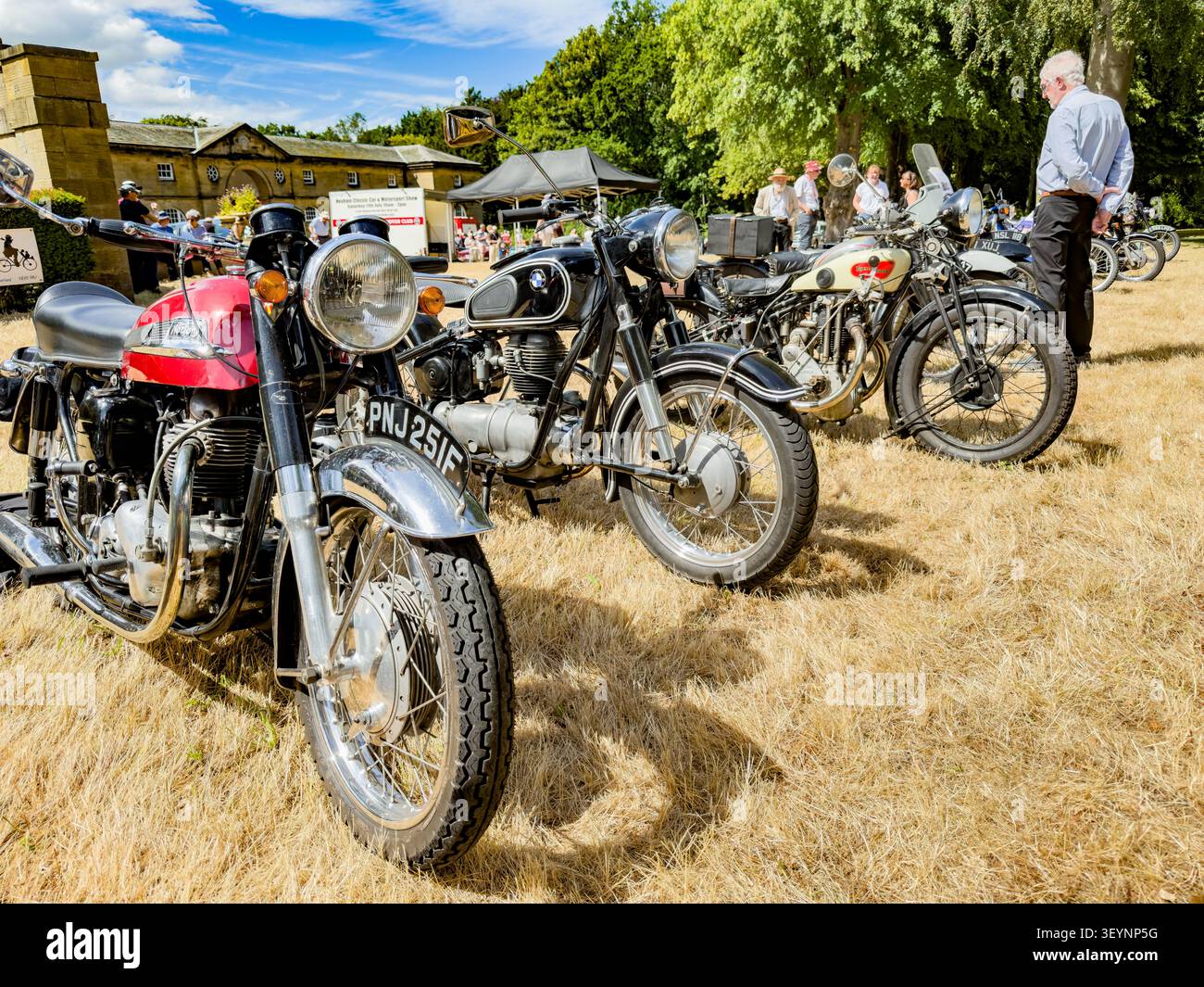 Motociclette classiche, tra cui una Royal Enfield rossa e una BMW nera esposte in occasione di una mostra di veicoli d'epoca in Inghilterra - Immagine stock catturata con smartphone
