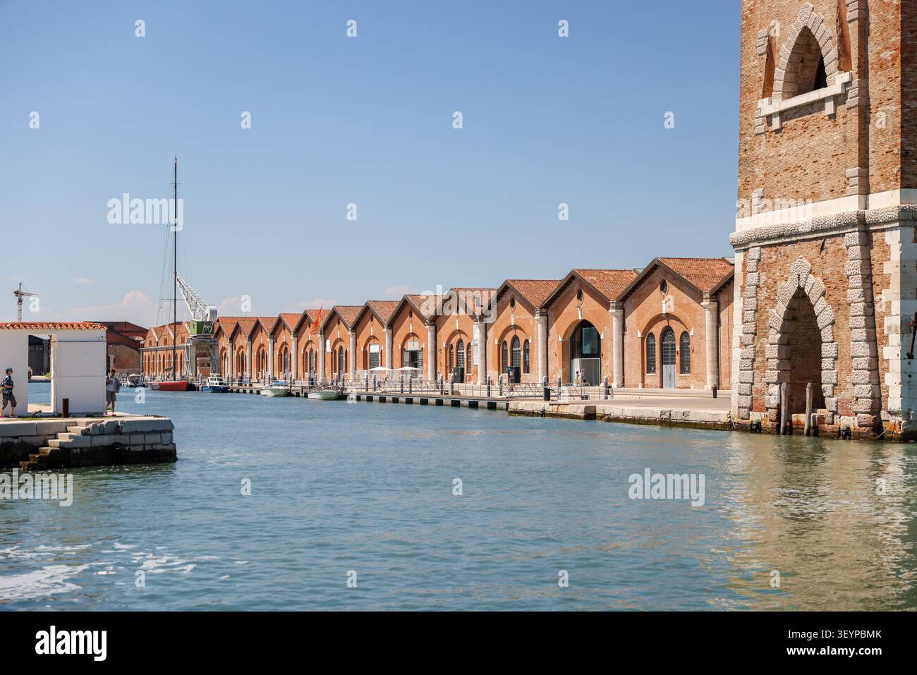 Magazzini storici in mattoni dell'Arsenale sul lungomare lungo un canale a Venezia, Italia, sede delle mostre della Biennale di Venezia. Foto Stock