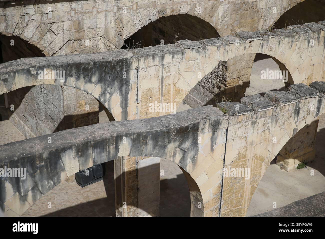 Archi in pietra storici e strutture a volta all'interno delle fortificazioni di Valletta, Malta. Foto Stock