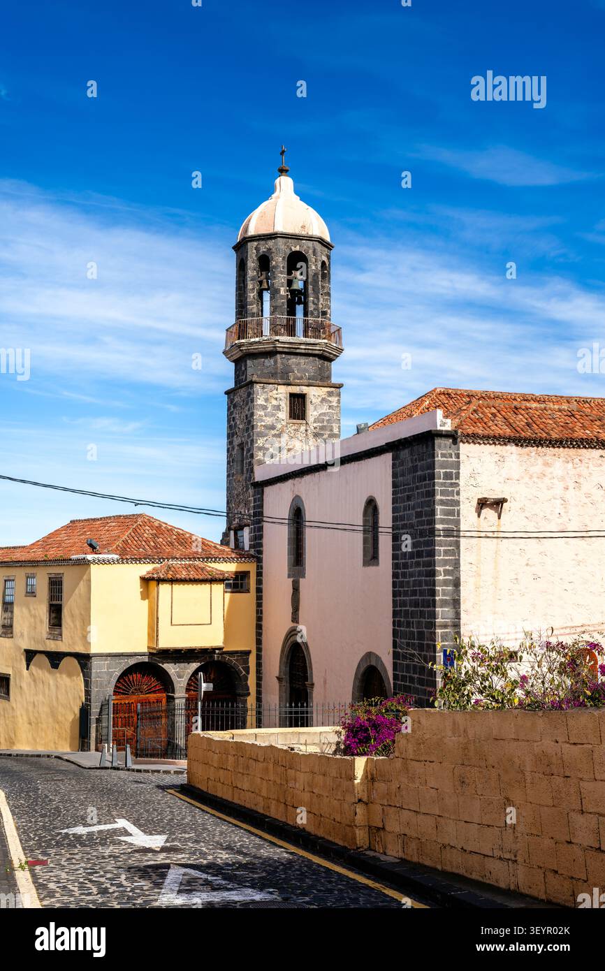Lo storico campanile della chiesa di Santo Domingo sorge su un cielo blu lungo una strada acciottolata a la Orotava, Tenerife, Spagna. Foto Stock