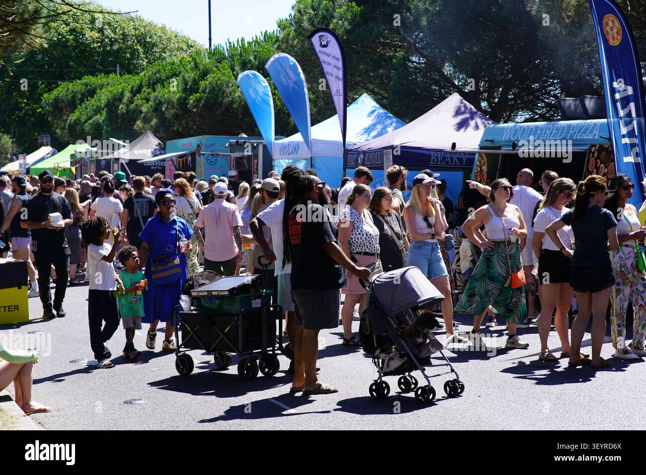 Una grande folla di visitatori si gode l'atmosfera soleggiata con camion e bancarelle al vivace Southsea Food Festival di Portsmouth, Inghilterra. Foto Stock