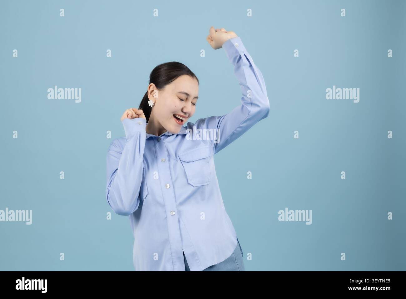 Donna incinta che allunga le braccia sentirsi attiva e sana in studio con blu Foto Stock