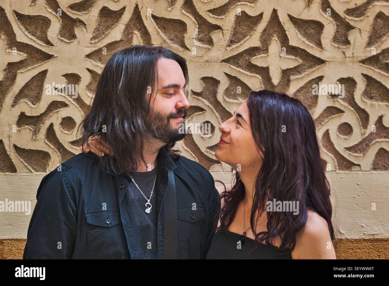 Ritratto ravvicinato di una giovane coppia che si guarda contro un muro decorativo. Foto Stock