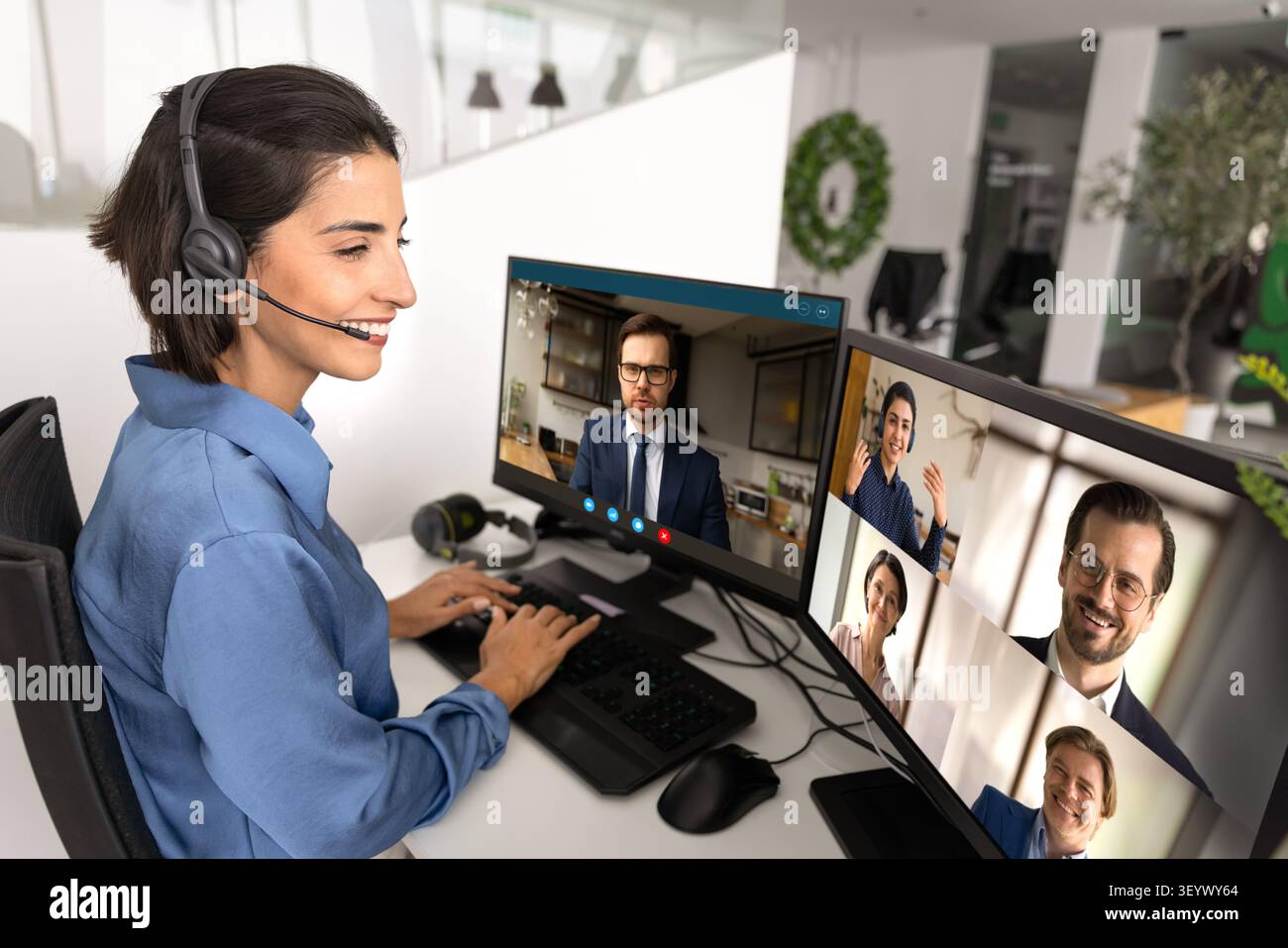 Lo specialista dell'assistenza clienti partecipa a videochiamate multischermo Foto Stock