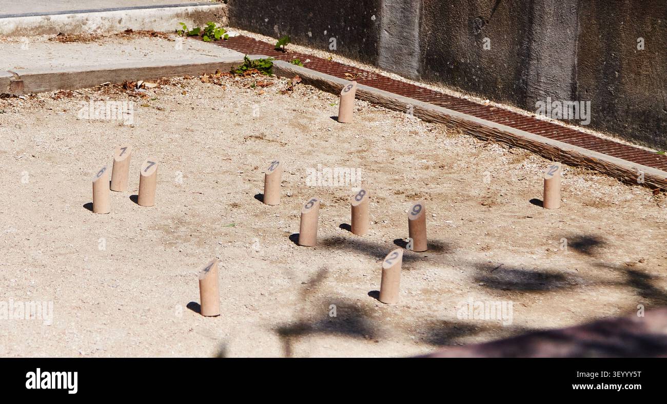 Spille Molkky posizionate su un terreno sabbioso in un'area esterna, evidenziando la tradizionale configurazione finlandese con elementi in legno distinti Foto Stock