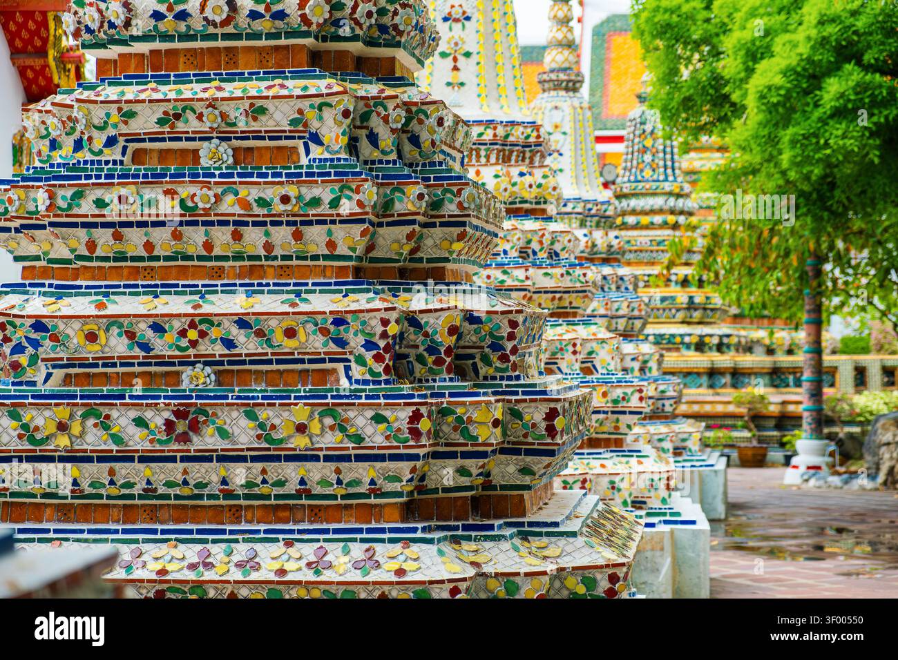 Chedi decorati a mosaico al complesso del tempio Wat Pho con dettagli in ceramica colorata e architettura buddista tradizionale nella città di Bangkok, Thailandia, Asia Foto Stock
