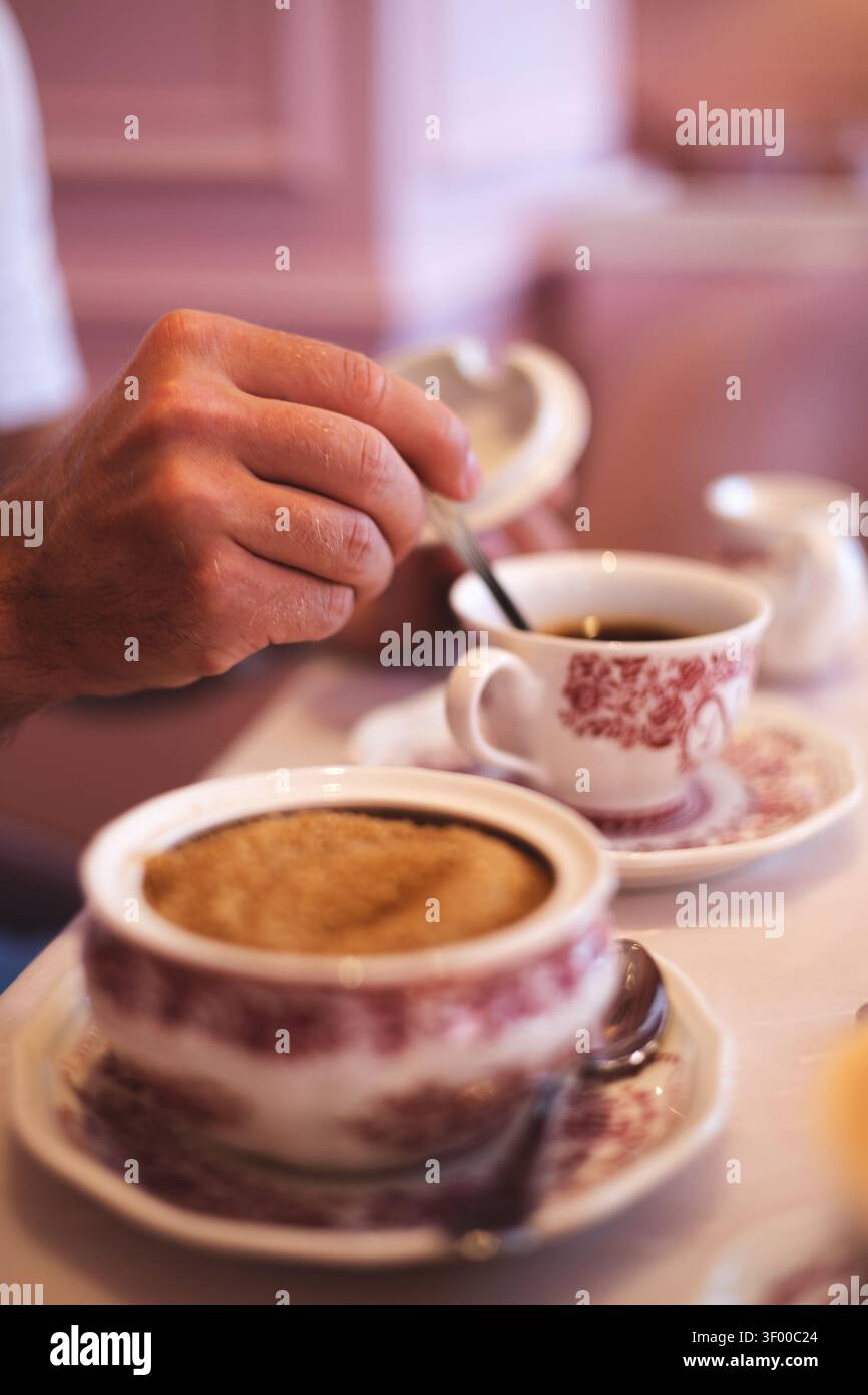 Un uomo beve il caffè mattutino da una tazza vintage Foto Stock