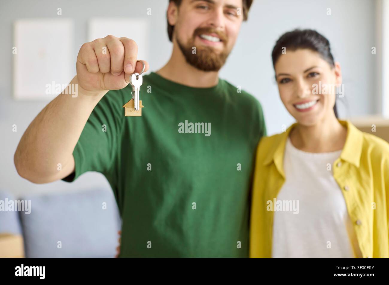 Coppia sorridente che mostra la nuova chiave della casa, celebra il trasferimento e il primo successo casalingo Foto Stock